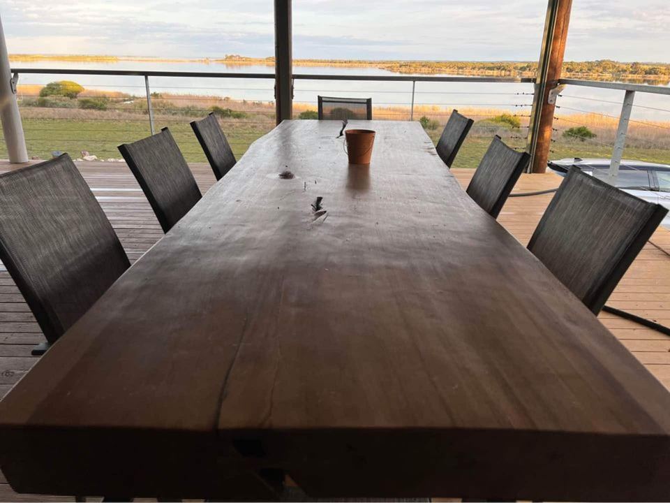 Long dining table seating the whole group, with the lake beyond
